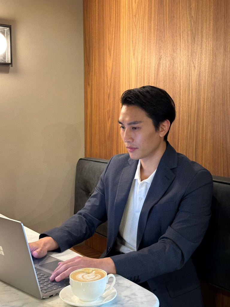 Male Model wearing WearTerry White Polo with a Navy Suit demonstrating the use case of WearTerry Polo in the office setting.