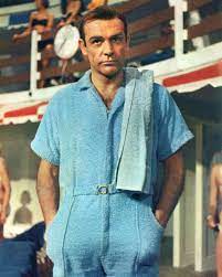 An image showing the iconic James Bond character wearing a sleek, blue terry cloth bathing suit. 